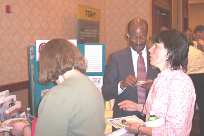 Exhibitor James Young (center), Acceletronics, speaks with attendees