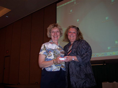 Lynn Justusson receives 5 year award from Marcia Phillips.