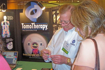 Greg Biggs (center), TomoTherapy, with SATRO attendees
