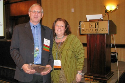 James Hugh, AMAC, accepts 10 Year Attendance Award from Director Marcia Phillips.